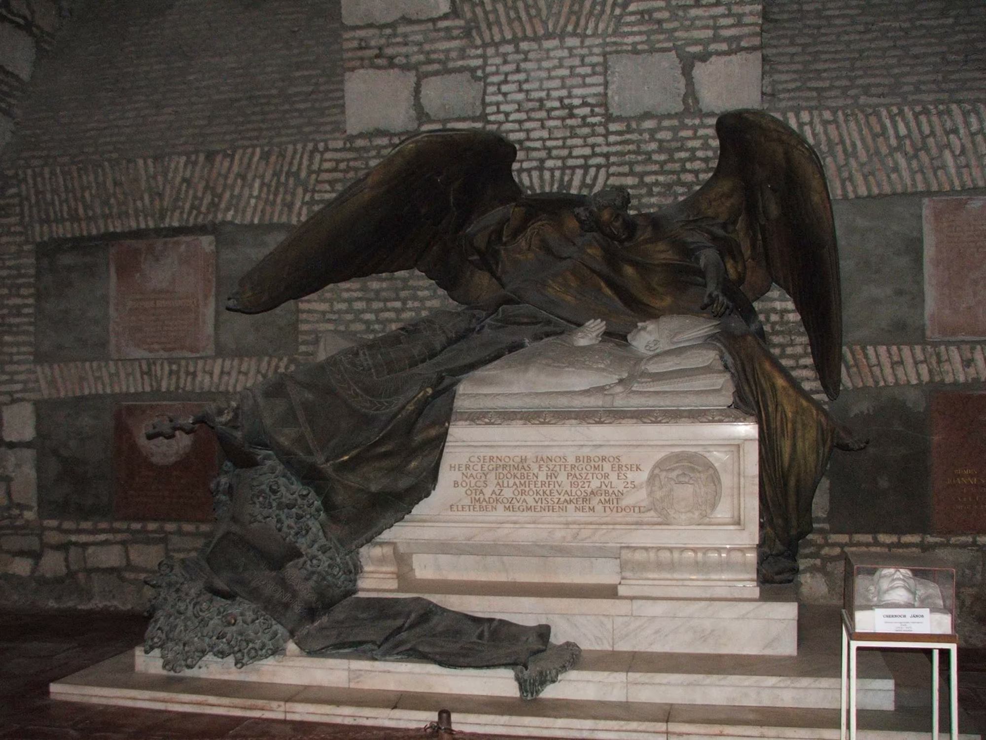 Die Krypta der Basilika: das Grabmal des Fürstprimas János Csernoch, ein Bronzeengel über weißem Marmorsarkophag.