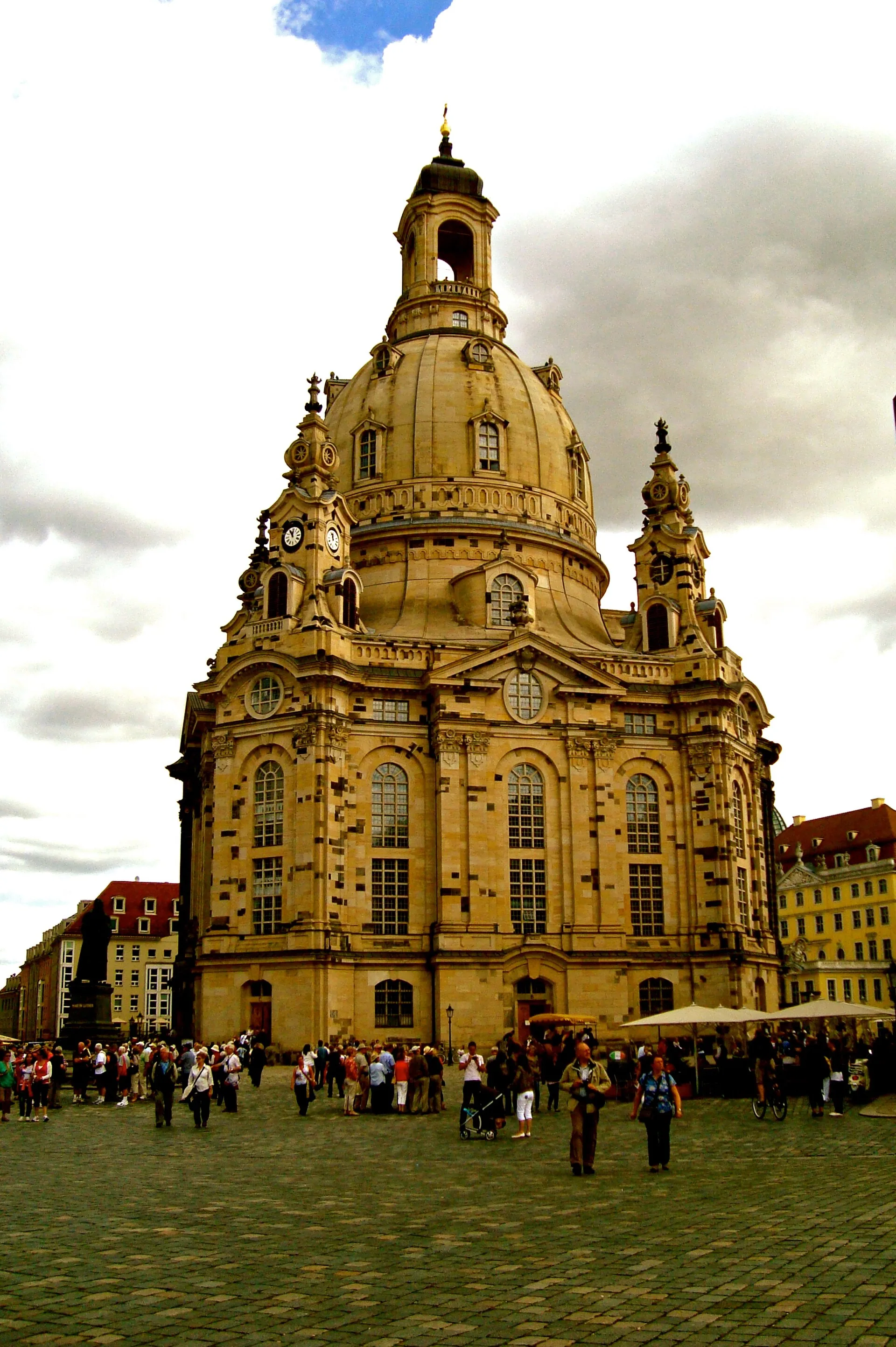 Außenansicht der Frauenkirche heute: die gesprenkelte Fassade, in der dunkle Originalsteine im hellen neuen Elbsandstein sitzen.