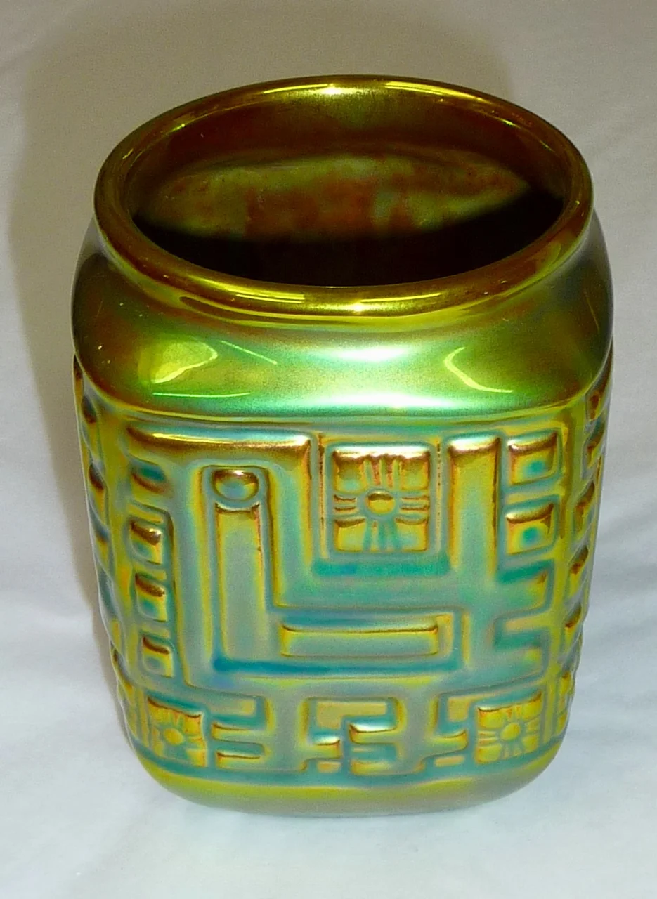 Nahaufnahme einer irisierenden Zsolnay-Eosin-Glasur — metallisch schillernde Oberfläche in Grün, Kupfer und Gold.