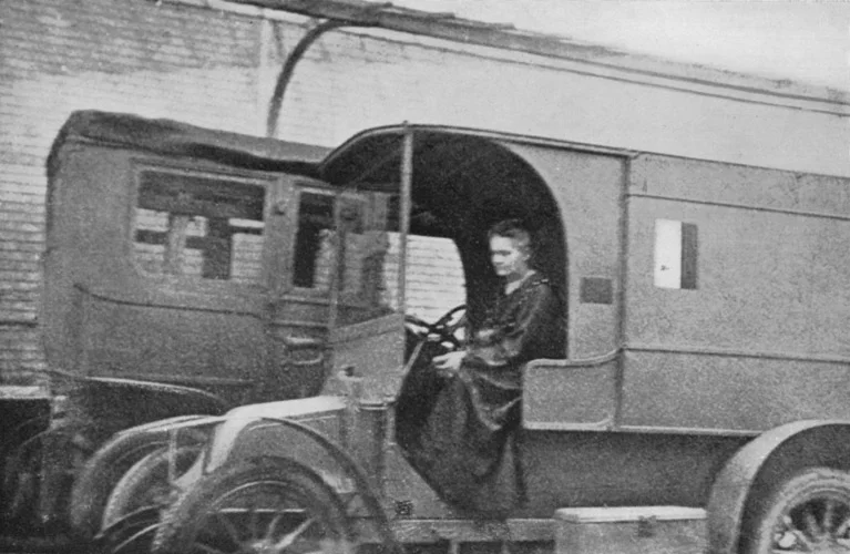 Historisches Foto: Marie Curie sitzt am Steuer eines umgebauten Automobils, einer mobilen Röntgeneinheit aus dem Ersten Weltkrieg