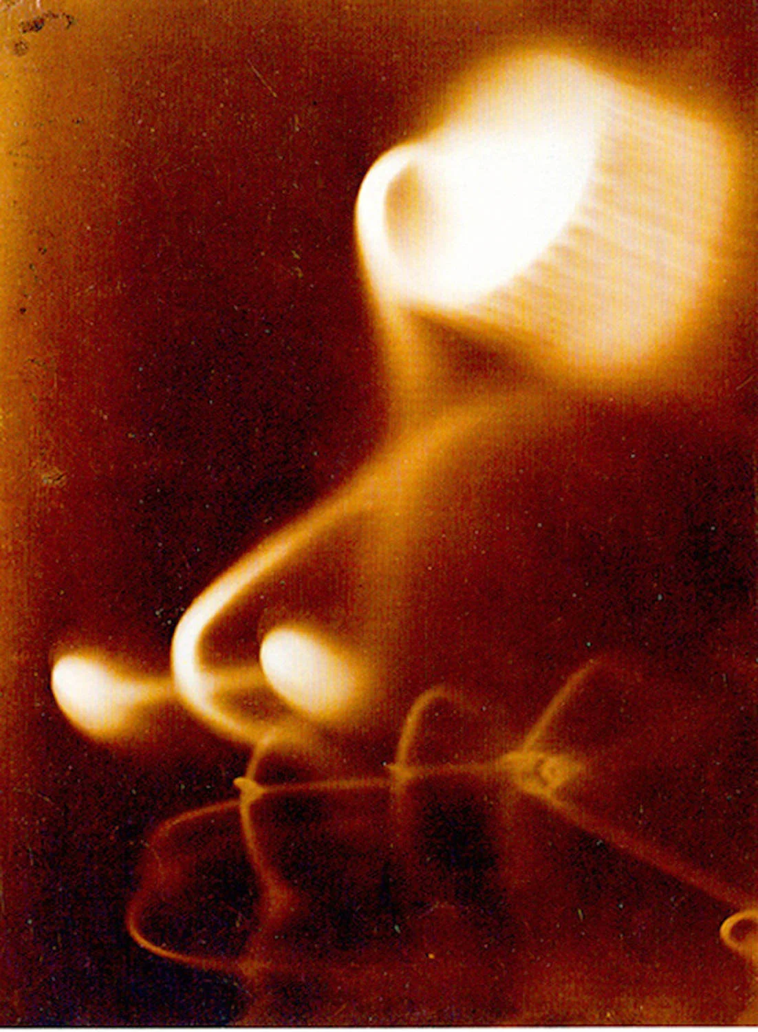 Fotogramm von László Moholy-Nagy aus dem Jahr 1923: helle und graue Formen schweben auf tiefschwarzem Grund, entstanden ohne Kamera durch direkte Belichtung.
