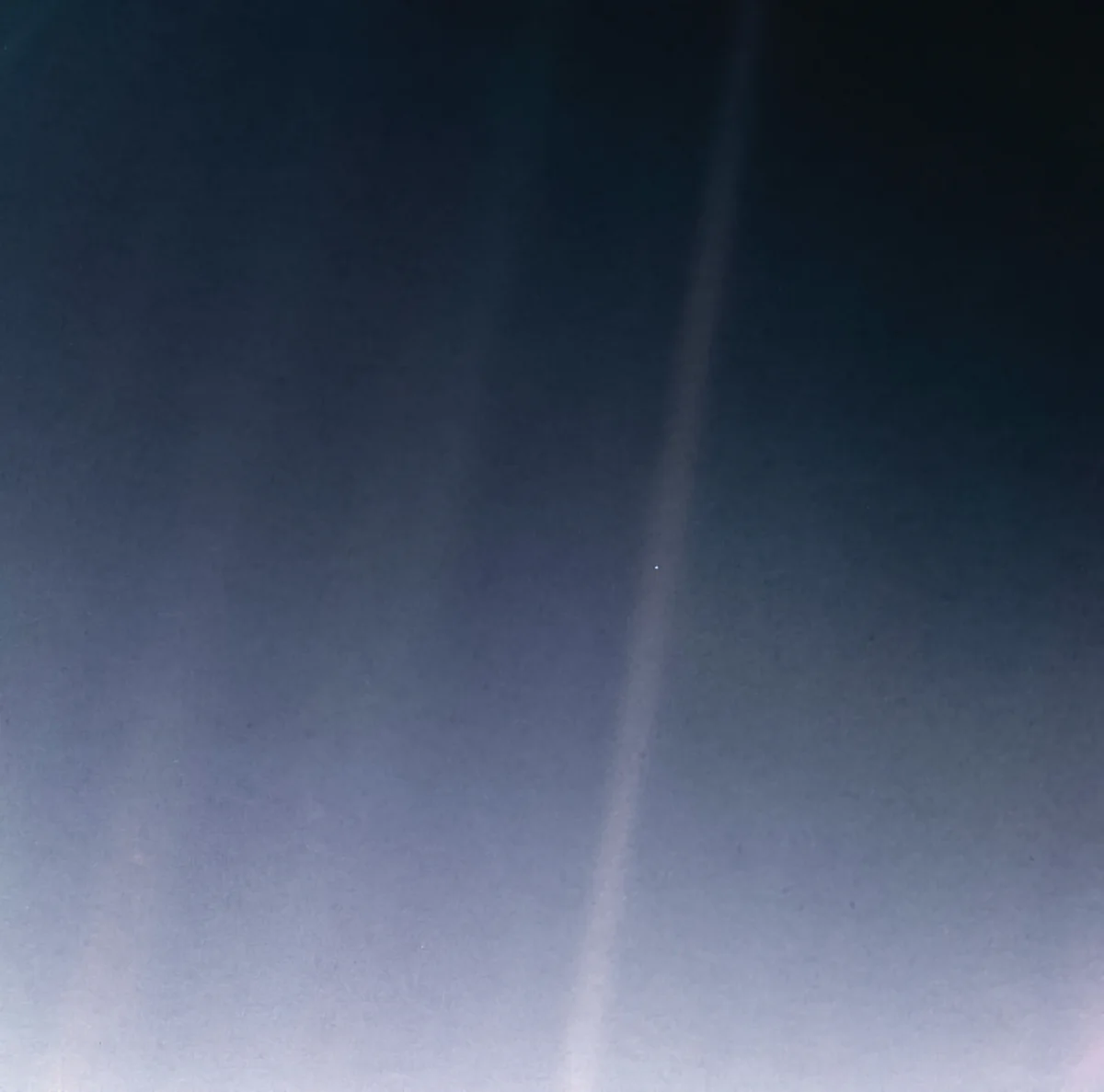 Die Erde als blasser blauer Punkt, kleiner als ein Bildpixel, in einem Streifen Streulicht. Aufgenommen von Voyager 1 am 14. Februar 1990 aus rund 6 Milliarden Kilometern. NASA/JPL-Caltech, gemeinfrei.
